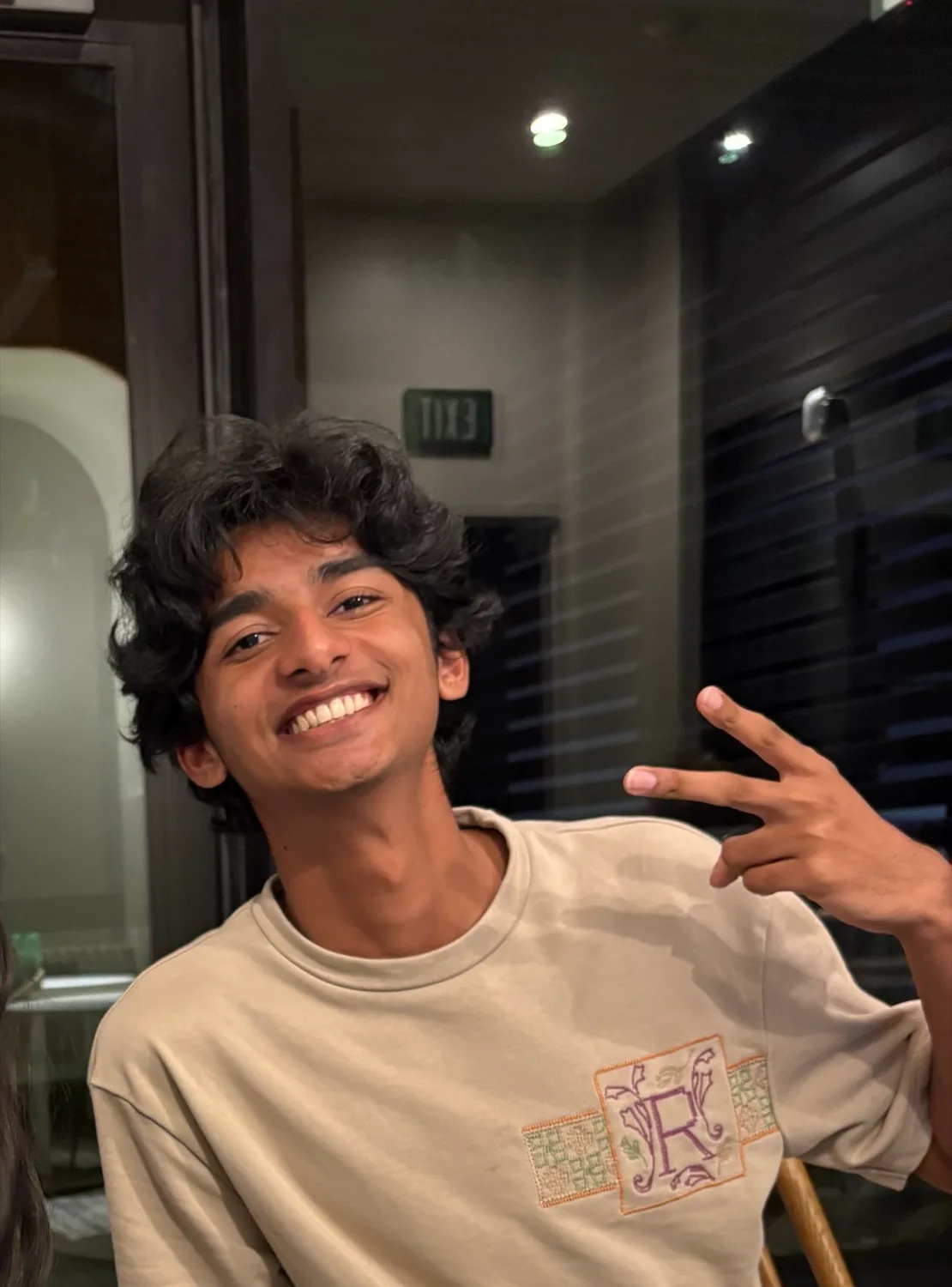 Aniketh smiling and giving a peace sign